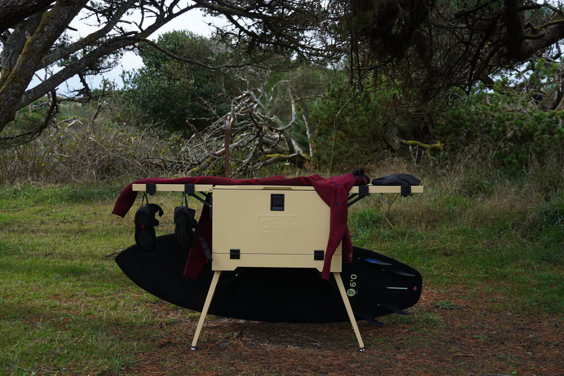 surfboard and a chuk camp kitchen box