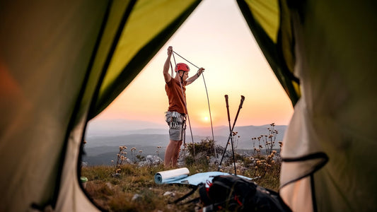 A guy tying knots to his tent